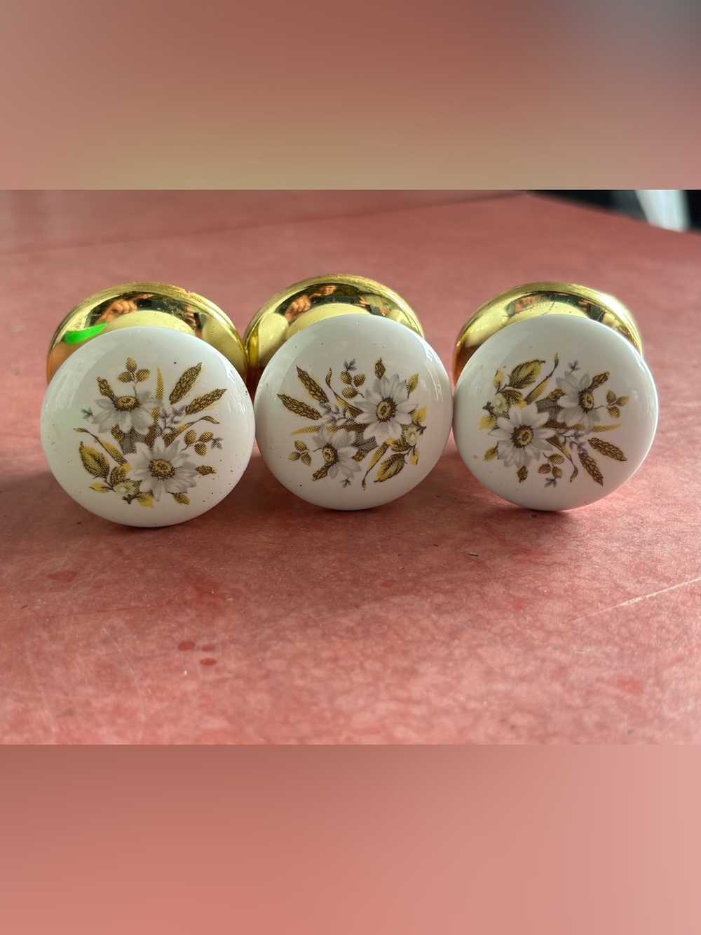 3x white glass knobs with floral motif